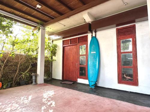 una tabla de surf azul al lado de una casa en Sana Studio, en Weligama