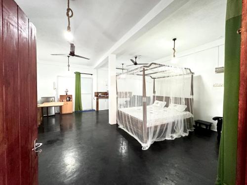1 dormitorio con cama con dosel en una habitación en Sana Studio, en Weligama