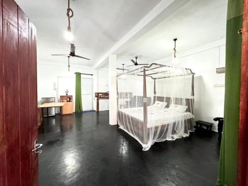 a bedroom with a canopy bed in a room at Sana Studio in Weligama