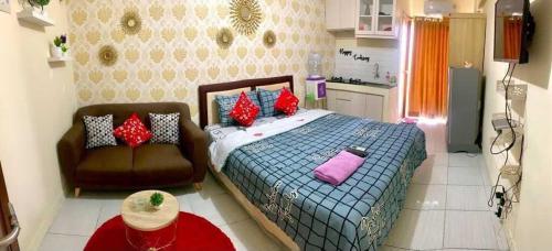 - une petite chambre avec un lit et un canapé dans l'établissement Megaroom Cinere Resort Apartment, à Gandul