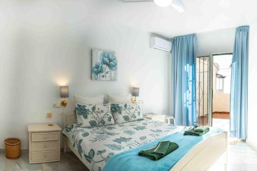 a bedroom with a bed with blue and white sheets at Golf/Seaview 2 bedroom apartment in Sitio de Calahonda - Mijas in Mijas