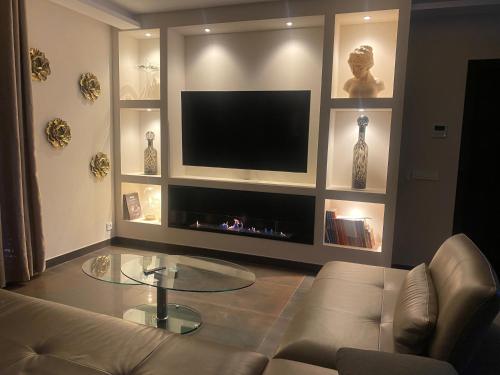 a living room with a couch and a flat screen tv at Domaine de La Franquette by Bridget & Pascal - Piscine Chauffée & SPA in Caderousse
