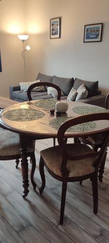 a wooden table and chairs in a living room at F2, entièrement neuf, 65m² in Montceau-les-Mines