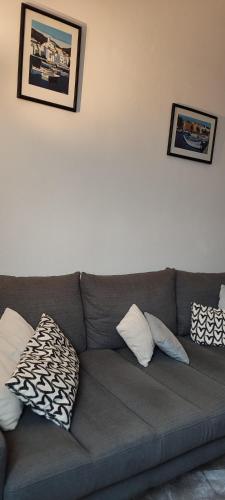 a gray couch with pillows on it in a living room at F2, entièrement neuf, 65m² in Montceau-les-Mines
