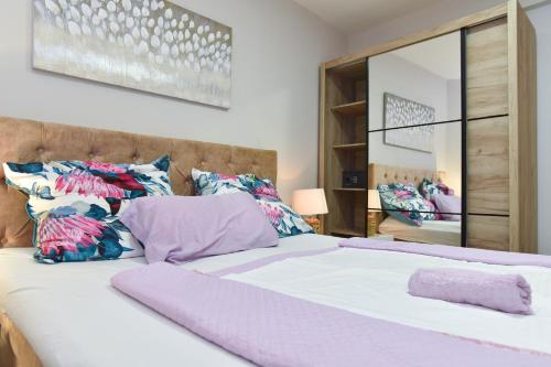 Un dormitorio con una cama grande con sábanas y almohadas púrpuras. en Apartment Vidar, en Budva