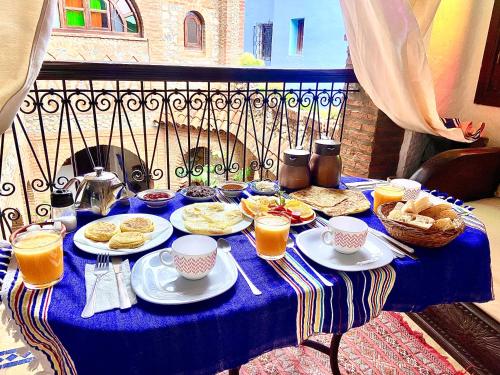 - une table bleue avec des aliments et des boissons pour le petit-déjeuner dans l'établissement Riad Gharnata, à Chefchaouen