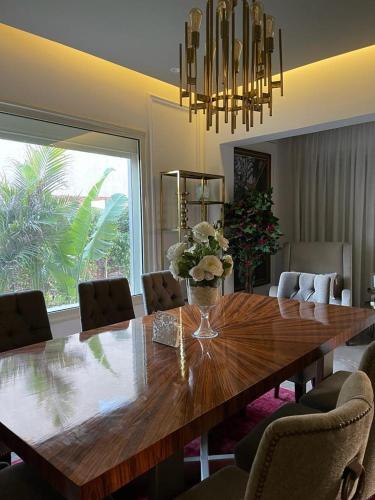 a dining room with a large wooden table and chairs at privet villa in palm hills in Sheikh Zayed