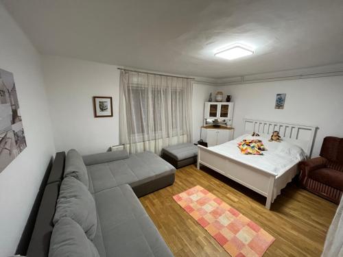 ein Wohnzimmer mit einem Sofa und einem Bett in der Unterkunft BB Fonyódi út Apartman in Balatonboglár