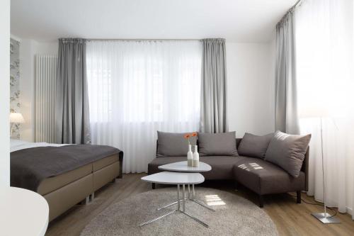 ein Schlafzimmer mit einem Bett, einem Sofa und einem Tisch in der Unterkunft Boardinghouse Münster in Münster
