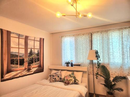 Seokchon Aerak في سول: غرفة نوم بسرير ونافذة كبيرة