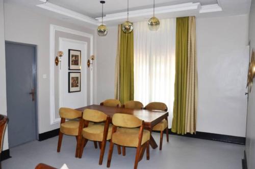 a dining room with a wooden table and chairs at RX Suites in Arua