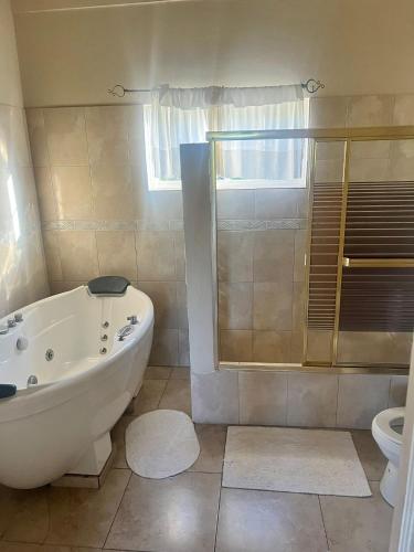 a bathroom with a tub and a toilet at Retreat Guest House in Falmouth