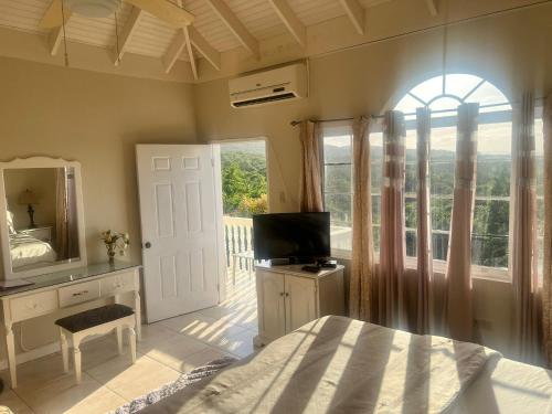a bedroom with a bed and a television and a window at Retreat Guest House in Falmouth