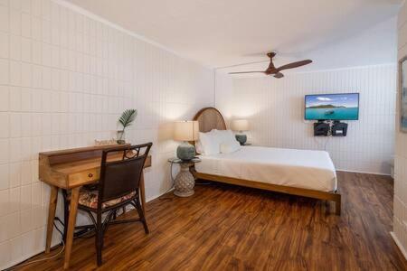 um quarto com uma cama e uma secretária com uma secretária. em Amazing Beachfront Condo em Hauula