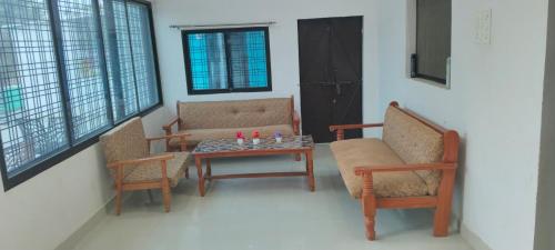a living room with two chairs and a table at Laxmi home stay in Ghūra