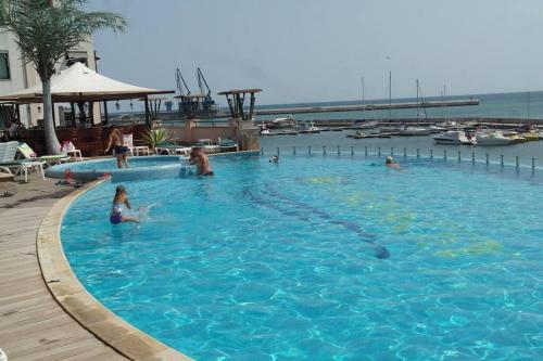 a group of people swimming in a large swimming pool at Cozy studio in Balchik in Balchik