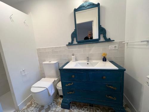 ein Badezimmer mit einer blauen Kommode und einem Spiegel in der Unterkunft El Pecu Casa Rural in Bustillo del Páramo