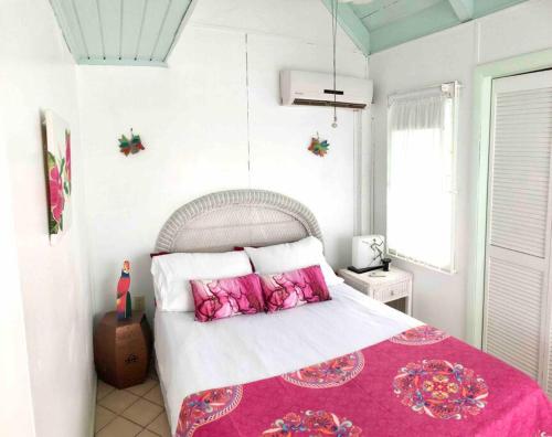 a bedroom with a large bed with pink pillows at 12 Sealofts On The Beach - Frigate Bay in Frigate Bay