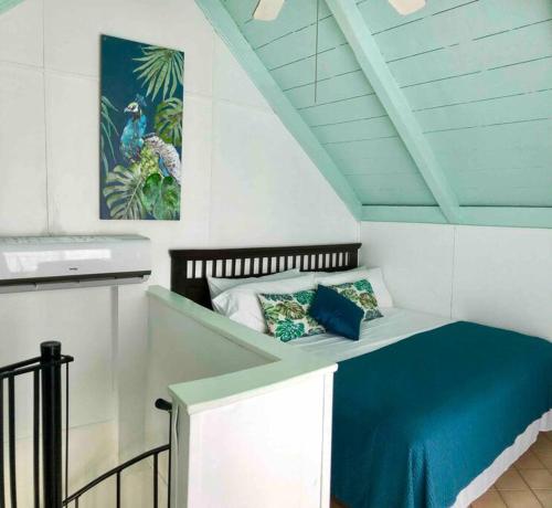 uma pequena cama num quarto com um cobertor azul em 12 Sealofts On The Beach - Frigate Bay em Frigate Bay