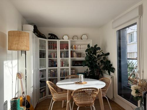 une salle à manger avec une table et des chaises blanches dans l'établissement 15min From Paris Center - Bright Large Top Floor - 4BD, à Asnières-sur-Seine