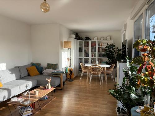 un salon avec un canapé et une table dans l'établissement 15min From Paris Center - Bright Large Top Floor - 4BD, à Asnières-sur-Seine