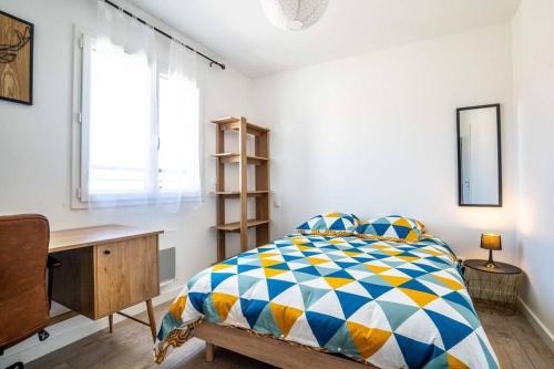 une chambre avec un lit, un bureau et une fenêtre dans l'établissement La Vauréenne - Maison Chaleureuse avec parking, à Lavaur
