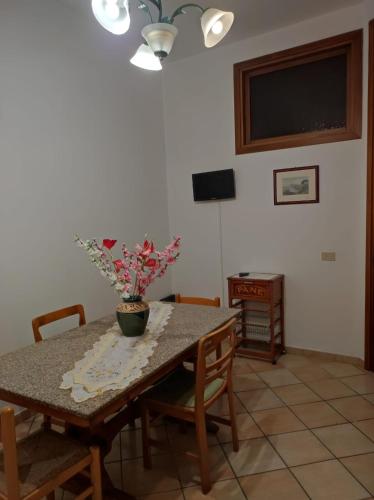 einen Esstisch mit einer Blumenvase darauf in der Unterkunft Casa vacanze vicoportone in Gaeta