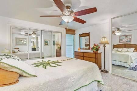 a bedroom with a bed and a ceiling fan at Beautiful Condo Right on the Beach in Hauula