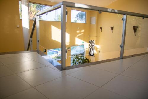 a room with a glass door in a building at MB Pousada SOL in Conde