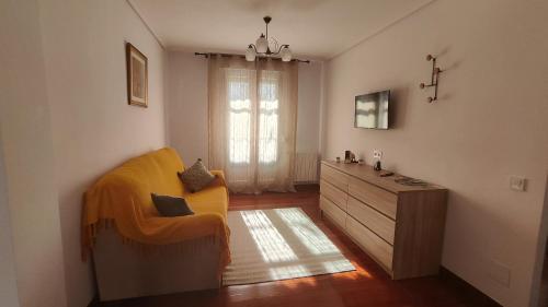 sala de estar con silla amarilla y cómoda en Apartamento céntrico, en Santander