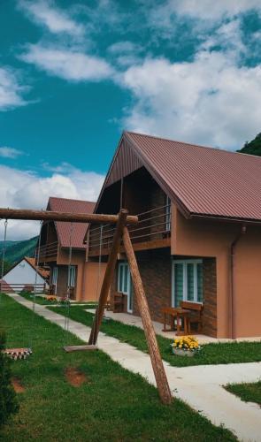 a house with a wooden structure in front of it at Guesthouse Madzarevic in Pluzine