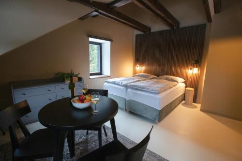 a bedroom with a bed and a table with a bowl of fruit at Penzion Mezi lesy in Nové Hutě