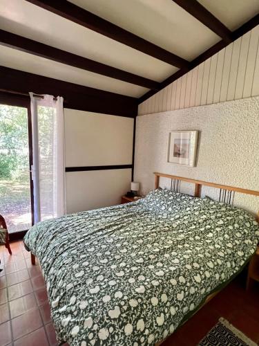 une chambre avec un lit avec une couette verte dans l'établissement La Girolle, à Lège-Cap-Ferret