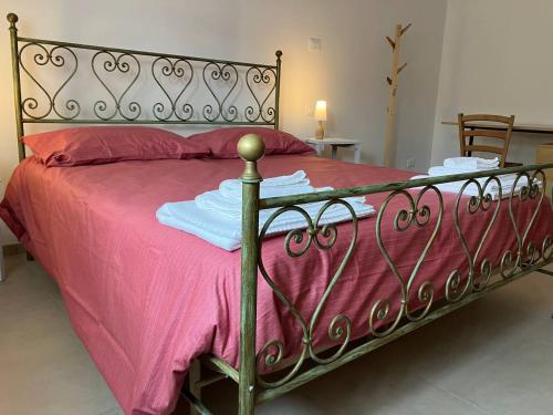 a metal bed with pink sheets and a pink blanket at MAISON ANZIO E ROSA in Ravenna