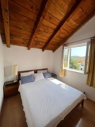 a bedroom with a large white bed with a window at Villa Sunce in Jezera