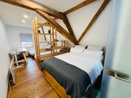 een slaapkamer met een bed in een kamer met houten balken bij Ferienwohnung am Schlössle in Ochsenfurt