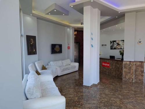 Adil Butik Otel في ديديم: غرفة معيشة مع أرائك بيضاء في غرفة