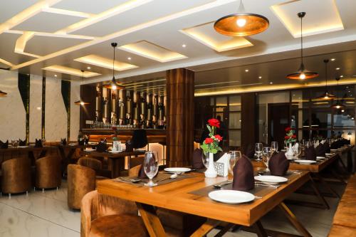 a restaurant with wooden tables and chairs and a bar at Accom Hotel in Ilām