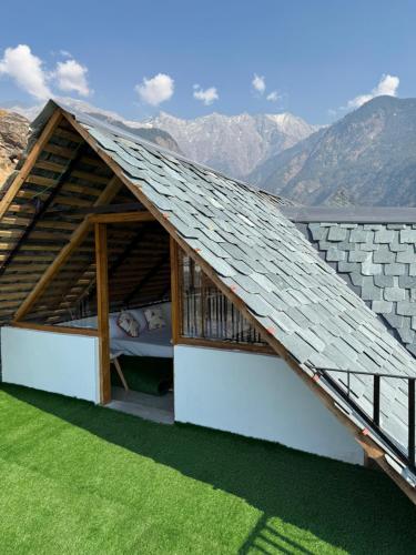 a building with a roof with a bed in it at Snow Biscuit Huts in Dharamshala