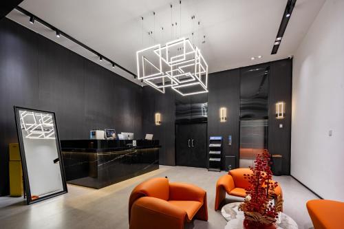 a lobby with orange chairs and a chandelier at Trip Voicer Chengdu Wide and Narrow Alley in Chengdu