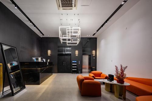 a living room with orange furniture and a chandelier at Trip Voicer Chengdu Wide and Narrow Alley in Chengdu