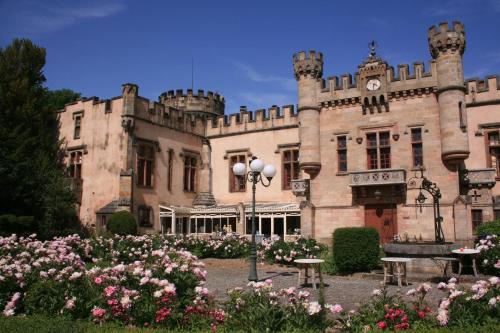 an old castle with flowers in front of it at Château de la Grange Fort in Issoire