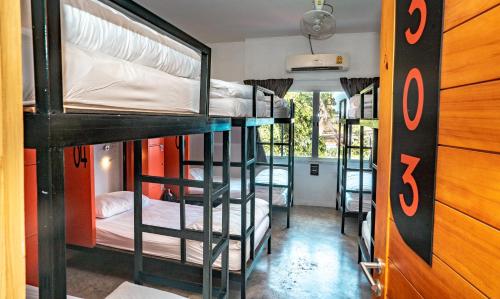 a room with three bunk beds in a house at Mad Monkey Chiang Mai in Chiang Mai