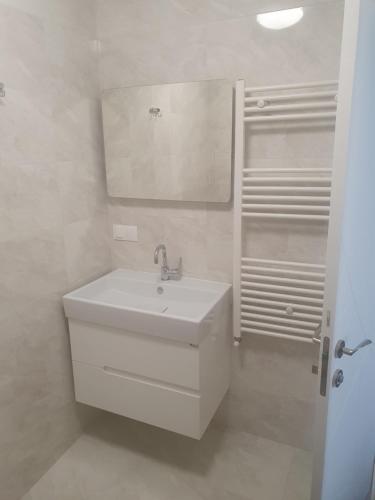 bagno bianco con lavandino e specchio di Димоти Апартхотел a Sofia
