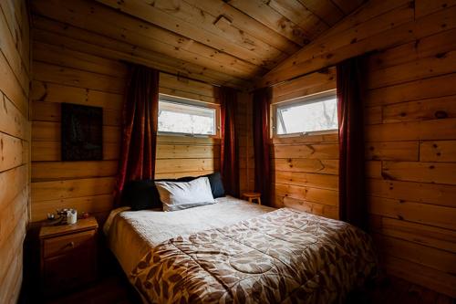 Rafting Momentum في Bryson: غرفة نوم مع سرير في كابينة خشب