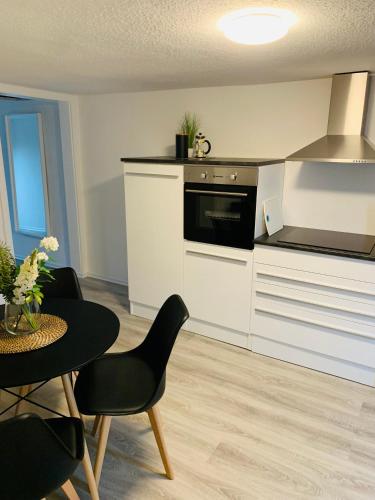 a kitchen with white cabinets and a table with chairs at Blaue 8 -2 in Leezen
