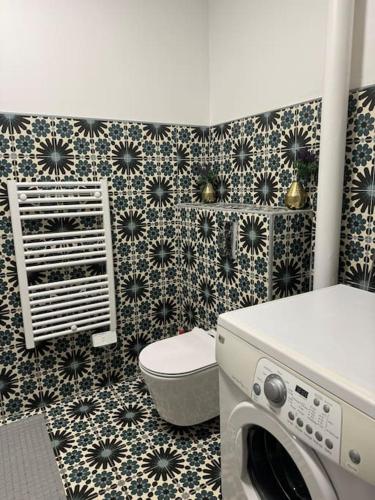 a bathroom with a washing machine and a toilet at Appartement Éloi - 1 Chambre in Mont-de-Marsan