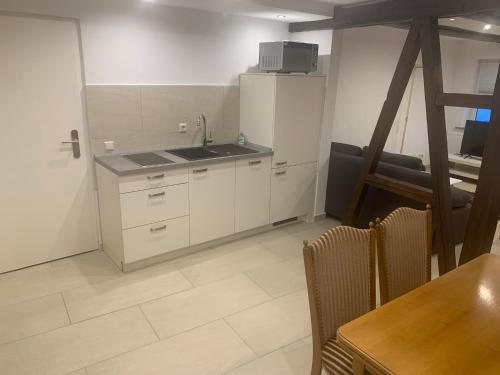 uma cozinha com um lavatório e uma mesa com cadeiras em Boardinghouse Schnaitheim - Apartment em Heidenheim an der Brenz