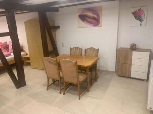 uma sala de jantar com uma mesa de madeira e cadeiras em Boardinghouse Schnaitheim - Apartment em Heidenheim an der Brenz