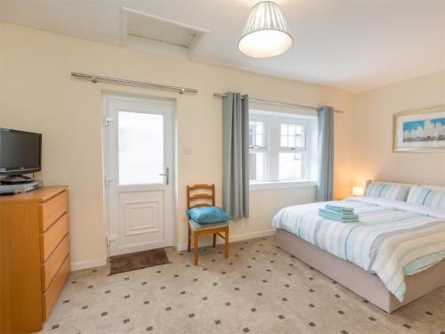 um quarto com uma cama, uma televisão e uma cadeira em 5 Bed in Brodick CA016 em Brodick